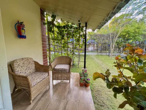 a screened in porch with a chair and plant at Bougainvillea Retreat & Spa in Kāhārpāra