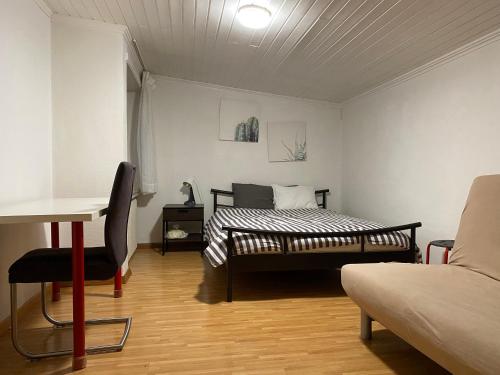 1 dormitorio con cama, mesa y sofá en Apartment CHEZ TONY, en Strassen