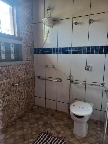 a bathroom with a toilet and a shower at Pousada Cachoeiras do Cipó in Serra do Cipo