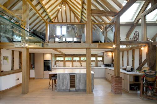 a large kitchen with wooden beams and a ceiling at A Barn at South Downs Stay in Houghton