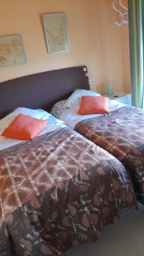 twee bedden naast elkaar in een slaapkamer bij Apartamanto FRENTE AL MAR, un dormitorio con dos camas, mas otra cama abatible en el salon in Benicàssim