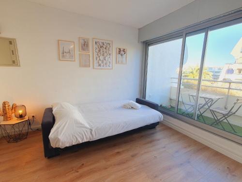 a bedroom with a bed and a large window at Suite Thalassa première ligne Couchant Wifi - ROSSIconciergerie - Linge inclus in La Grande Motte