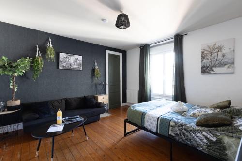 une chambre avec un lit et un canapé dans l'établissement L'appart K-ctus - Moderne et design, 4 pers, au Mans