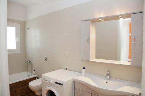 uma casa de banho com um lavatório, um WC e um espelho. em Villa Evita , suites 1, Athytos,63m2,a/c,privacy em Afitos