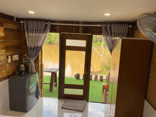 a kitchen with a door open to a yard at Floor river view in Cat Tien