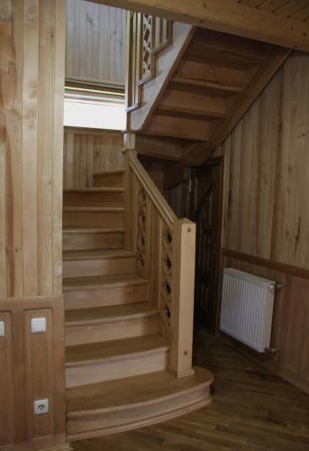 a wooden staircase in a room with wooden walls and wooden floors at Чорногірський Вітер in Verkhovyna