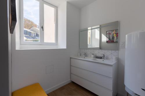 une salle de bain blanche avec un lavabo et une fenêtre dans l'établissement L'appart K-ZA Wifi Fibre Checkin auto 6 pers, au Mans