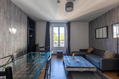 un salon avec un canapé et une table en verre dans l'établissement L'appart K-ZA Wifi Fibre Checkin auto 6 pers, au Mans