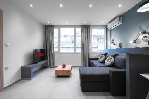 uma sala de estar com um sofá e uma televisão em Bliss Apartments, The Luxury Suites em Tessalónica