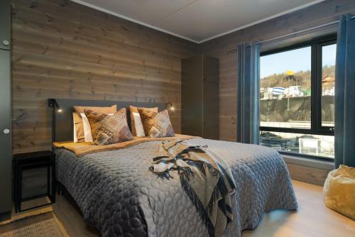 1 dormitorio con 1 cama con pared de madera en Delikat leilighet i Riddertunet en Beitostøl