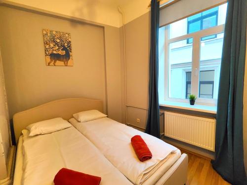 a small bedroom with a bed and a window at Gleznotaju Old Town Two Bedroom Apartment in Rīga