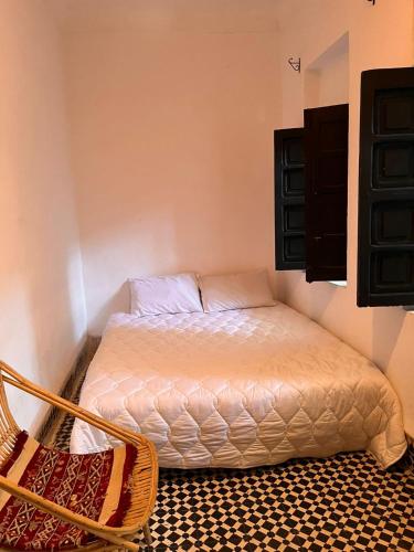 a small bedroom with a bed and a chair at Riad TaTam House in Marrakech