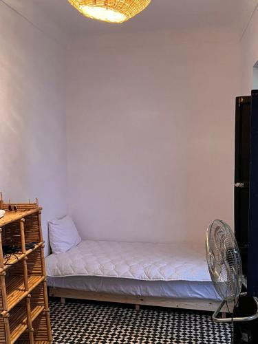 a room with a bed and a fan at Riad TaTam House in Marrakech