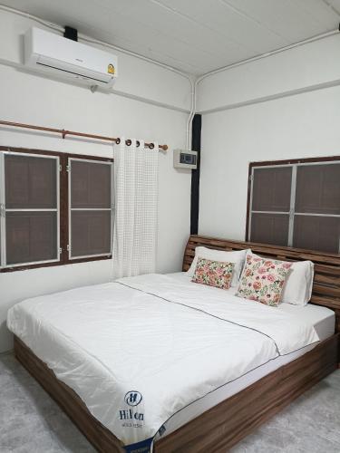 a bedroom with a large bed with white sheets and pillows at ไร่ดง โฮมเสตย์ in Ban Pong Nua