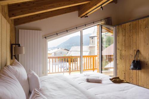 a bedroom with a bed and a large window at Triendlhof in Zöblen