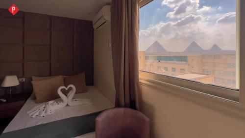 a room with a window with a bed with a heart on it at Pyramids View Guest House in Cairo