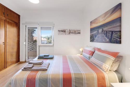 a bedroom with a large bed with towels on it at The Beach Place in Costa da Caparica