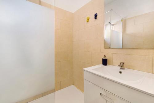 W łazience znajduje się umywalka i lustro. w obiekcie The Beach Place w Costa de Caparica