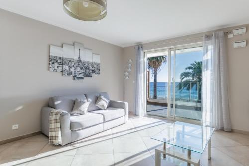 un salon avec un canapé et une vue sur l'océan dans l'établissement LE MIDI 8 by ESTATES CANNES, à Cannes