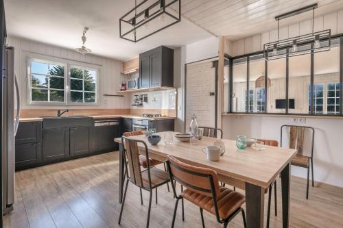 une cuisine avec une table et des chaises en bois dans l'établissement Séjour pour 11 - Jardin - Arzon, à Arzon
