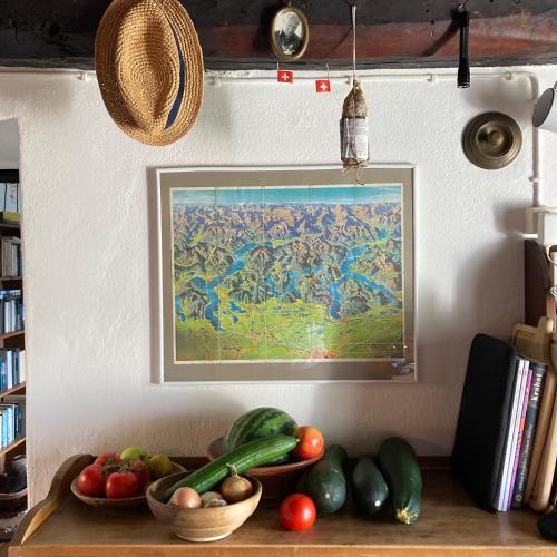 a plate of vegetables on a table with a painting at Casa Bruja Tradizionale Rustico Ticinese in Mergoscia