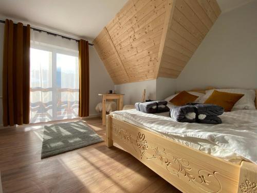 Willa Pod Wyciągiem في سبيتكوفيتسه: غرفة نوم بسرير كبير ونافذة كبيرة