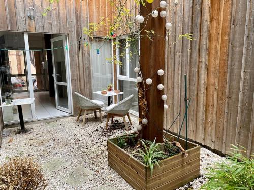 a patio with a table and chairs and a tree at Residences De Chartres in Chartres