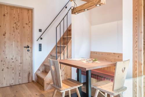 a room with a table and chairs and a staircase at Guntschöllerhof Rotwand in Fiè