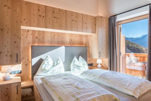 1 dormitorio con cama y ventana grande en Guntschöllerhof Rotwand en Fiè