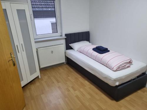 ein kleines Bett in einem Zimmer mit Fenster in der Unterkunft Ferienwohnung Kassel Zentral in Kassel