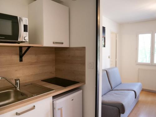 a kitchen with a sink and a microwave at Motel 991 in Viviers-du-Lac