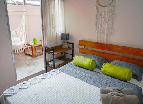 a bedroom with a large bed with green pillows at Apartamentos y Studios Brisas del Mar Santa Teresa in Santa Teresa Beach