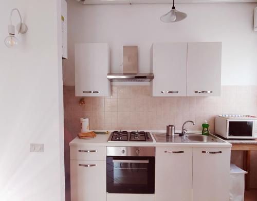 a kitchen with white cabinets and a stove top oven at IEO -Humanitas - SUNNY HOUSE - Comodissimo in Locate di Triulzi