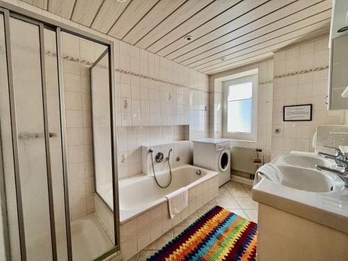 uma casa de banho com um chuveiro, uma banheira e um lavatório. em Landhaus-Chalet-Keilberger Blick em Kurort Oberwiesenthal