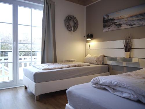 2 camas en una habitación con ventana en Ferienhaus Oceansounds, en Sierksdorf