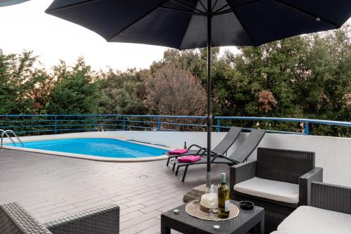 a patio with an umbrella and a swimming pool at Vila Tina in Pula, Istrien in Medulin