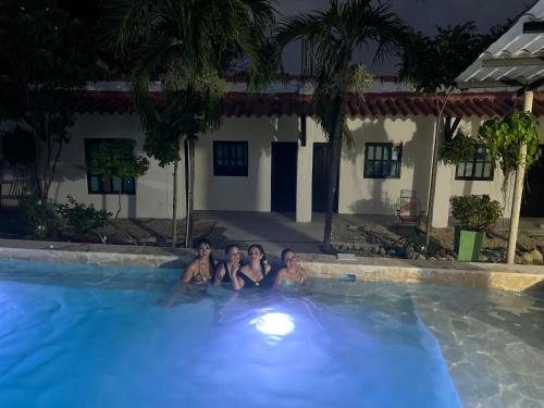 three women sitting in a swimming pool at night at Casa Torices Real 12 in Cartagena de Indias