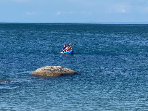 two people are sitting in a boat in the water at The Beach Shack Glamping & The Boat Shed in St Helena Bay