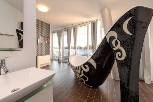 a bathroom with a black and white chair in a room at Vila Tina in Pula, Istrien in Medulin
