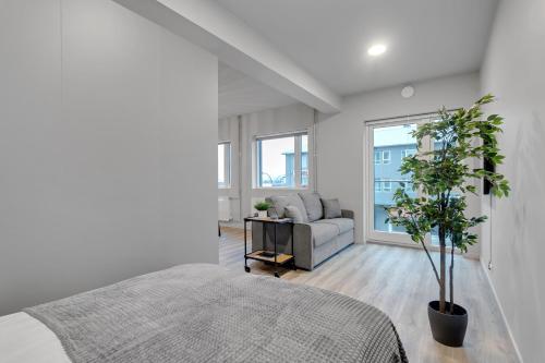 een witte slaapkamer met een bed en een bank bij Sunny Central Apartment in Reykjavík