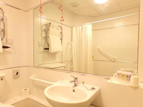 W białej łazience znajduje się umywalka i lustro. w obiekcie Fox and Goose Inn w mieście Brent Knoll