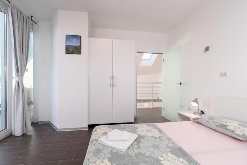 a white bedroom with a bed and a window at Vila Tina in Pula, Istrien in Medulin
