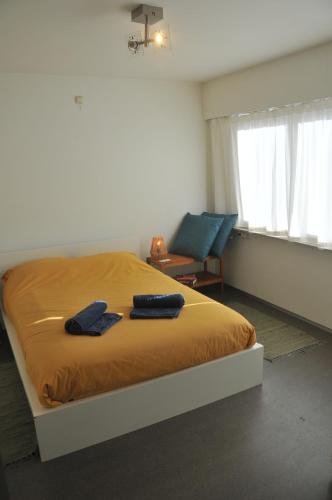 a bedroom with a bed with two blue towels on it at at Number 1 in Rumst