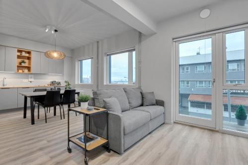 een woonkamer met een bank en een tafel bij Sunny Central Apartment in Reykjavík