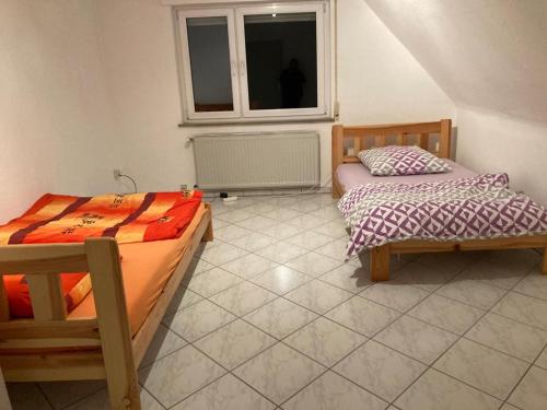 two beds in a room with a window at Monteurunterkunft Wiesental in Waghäusel