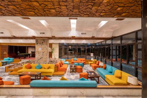 a lobby with orange and blue couches and tables at Aracan Eatabe Luxor Hotel in Luxor