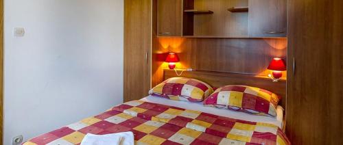 a bedroom with a bed with two pillows and two lamps at Apartment in Novalja with sea view, terrace, air conditioning, WiFi 3565-6 in Novalja
