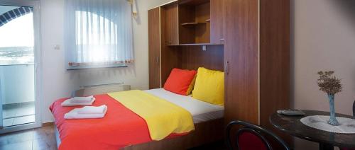 una camera da letto con un letto con cuscini colorati e un tavolo di Studio apartment in Novalja with sea view, terrace, air conditioning, WiFi 3565-7 a Novalja (Novaglia)