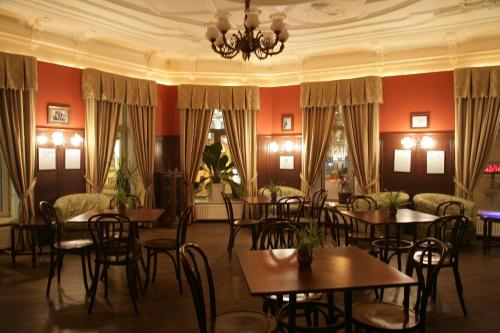 Old Vienna في سانت بطرسبرغ: غرفة طعام بها طاولات وكراسي وثريا
