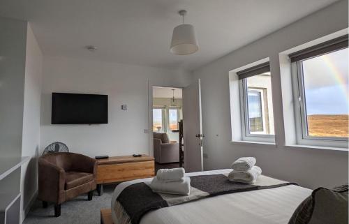 a bedroom with a bed and a tv and a chair at Ruadh in Ose